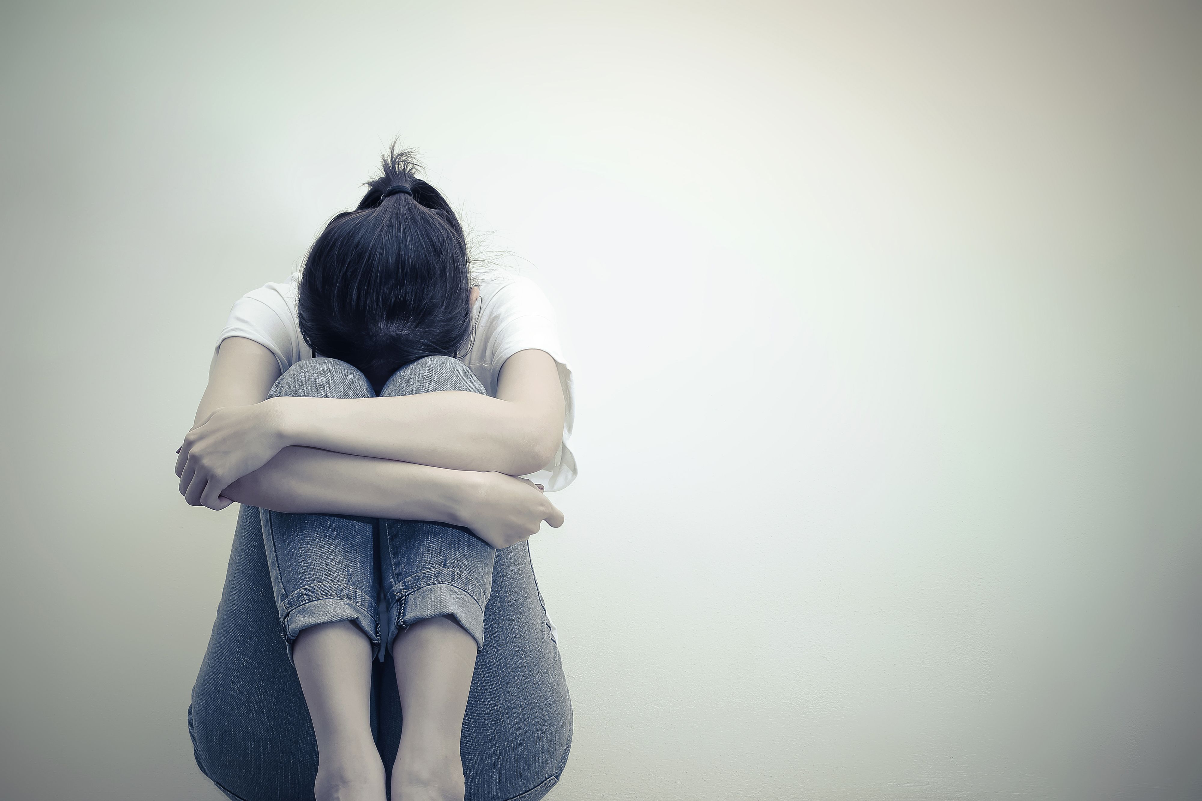 sad woman with her head resting on her knees